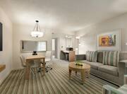 Spacious living area in accessible suite featuring TV, sofa, work desk, and wet bar.