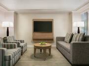 Spacious lounge area in presidential suite featuring comfortable seating and TV.
