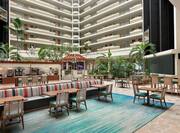 Spacious hotel atrium featuring ample seating, breakfast area, and bar.