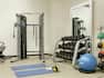 Convenient on-site fitness center featuring work out machines, free weights, and yoga mats.