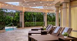 Spacious La Vista pool terrace featuring lounge chairs, towels, and beautiful string lights.