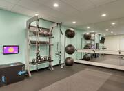 Convenient on-site fitness center featuring ample space, floor to ceiling mirror, and cross fit exercise equipment.