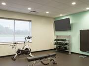 Convenient on-site fitness center fully equipped with spin bike, free weights, exercise mats, and TV.