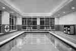 Beautiful large indoor pool featuring floor to ceiling windows, ample seating, and complimentary towels.