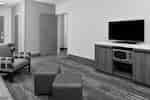 พื้นที่นั่งเล่นในห้องพักพร้อม HDTV เก้าอี้นวม และที่พักเท้าสองเตียง