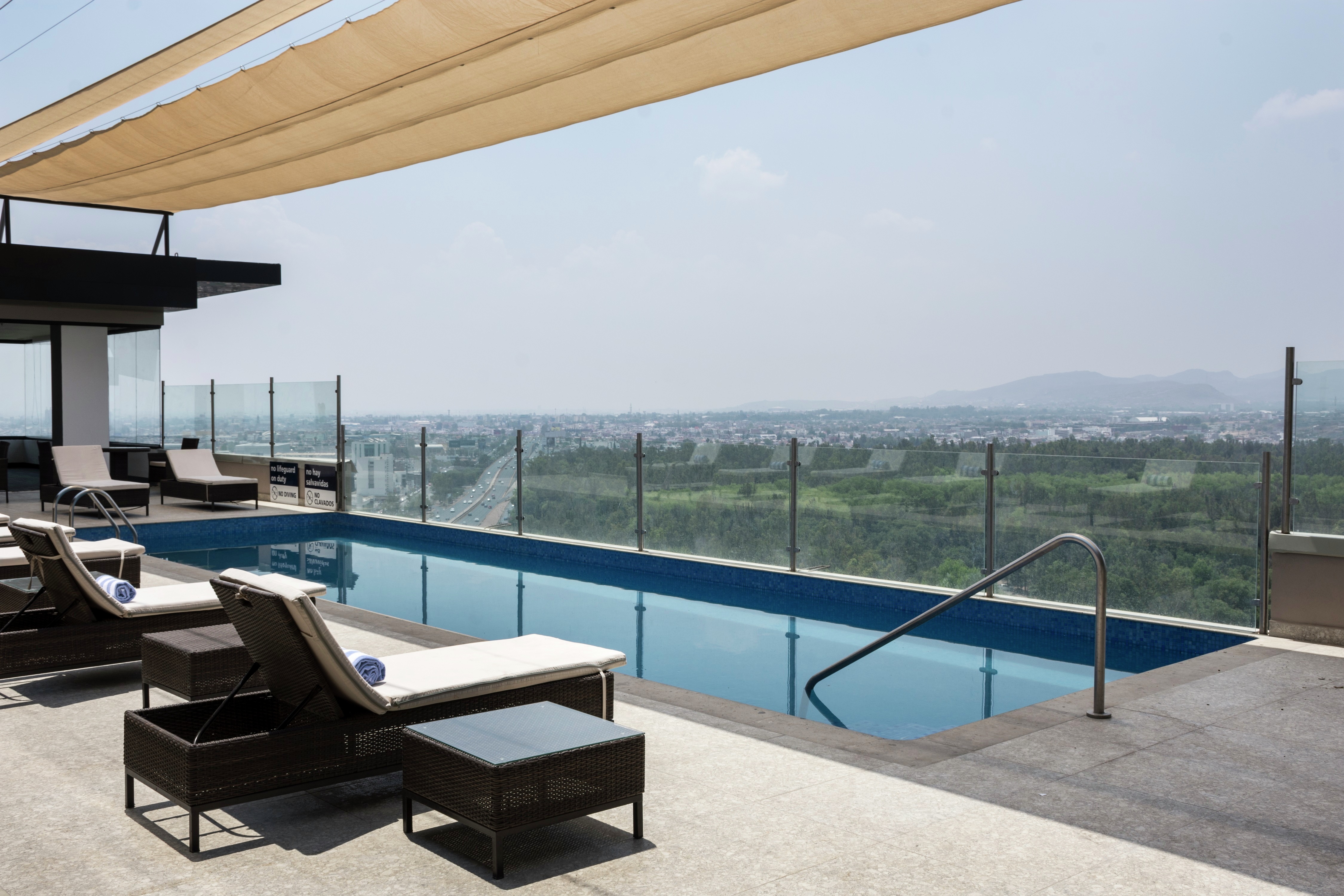 Rooftop Pool with Deck Chairs at Daytime