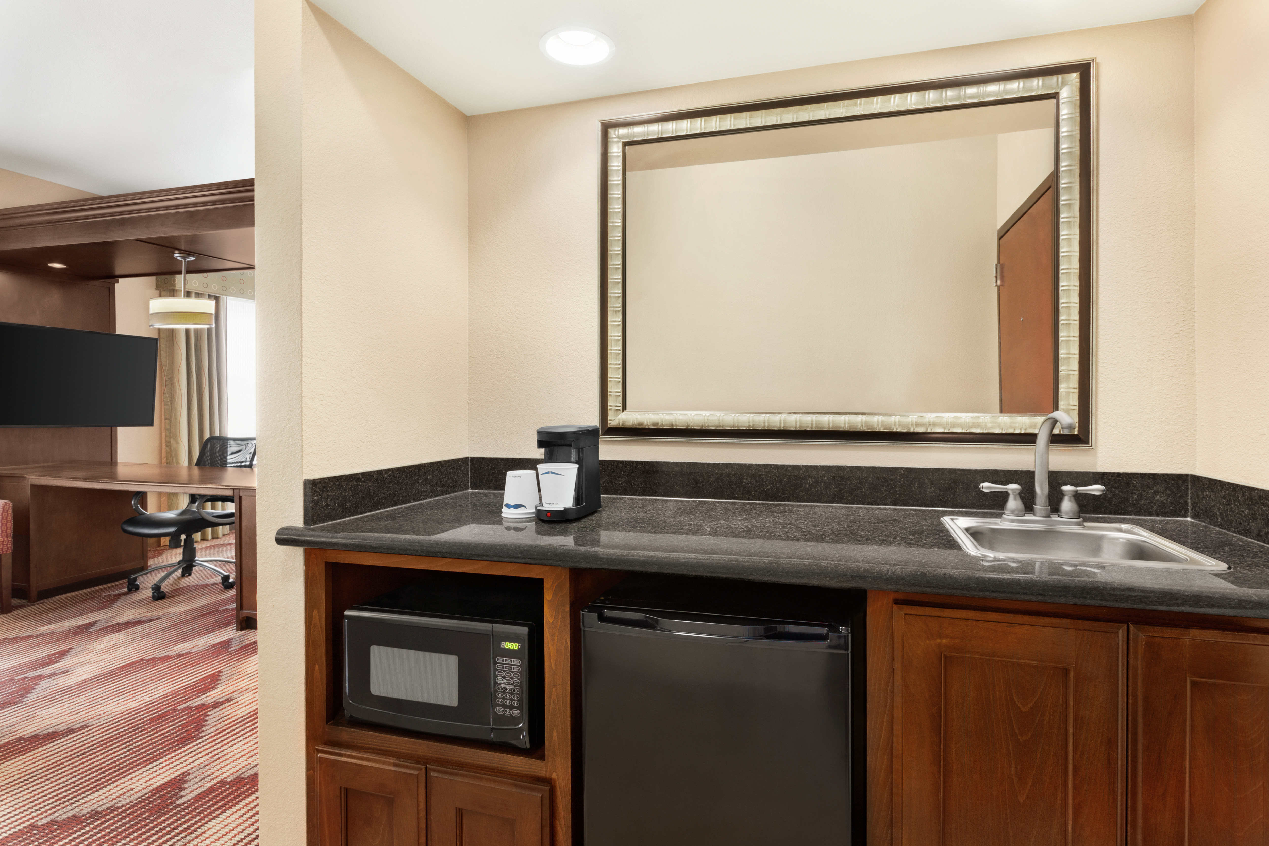 Spacious suite featuring convenient wet bar, work desk, and TV.