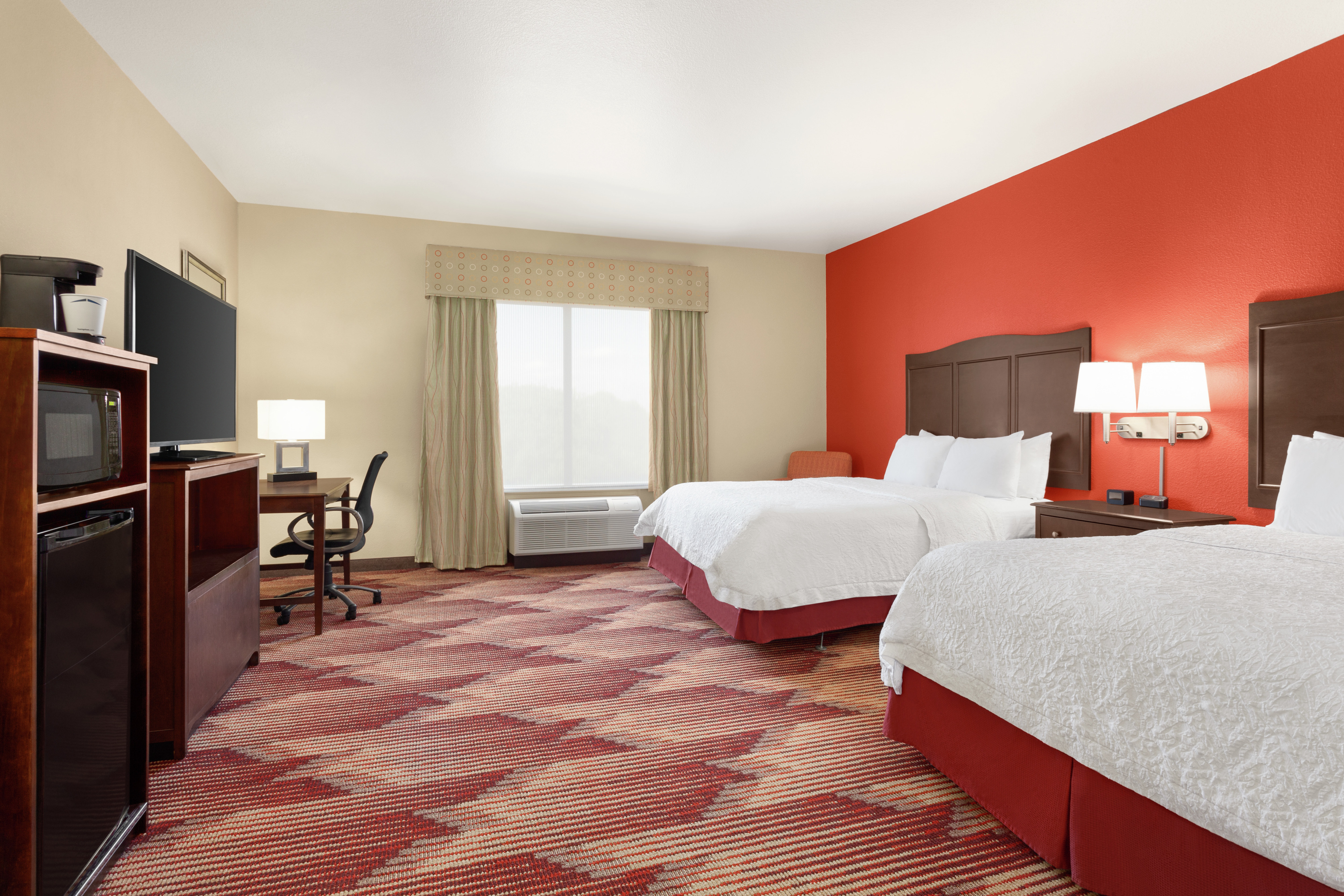 Spacious accessible guest room featuring two comfortable queen beds, TV, and work desk.