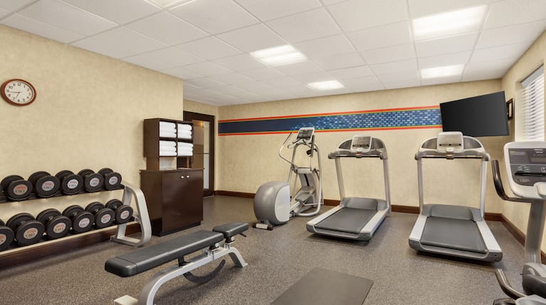 Convenient on-site fitness center featuring cardio machines, free weights, and TV.