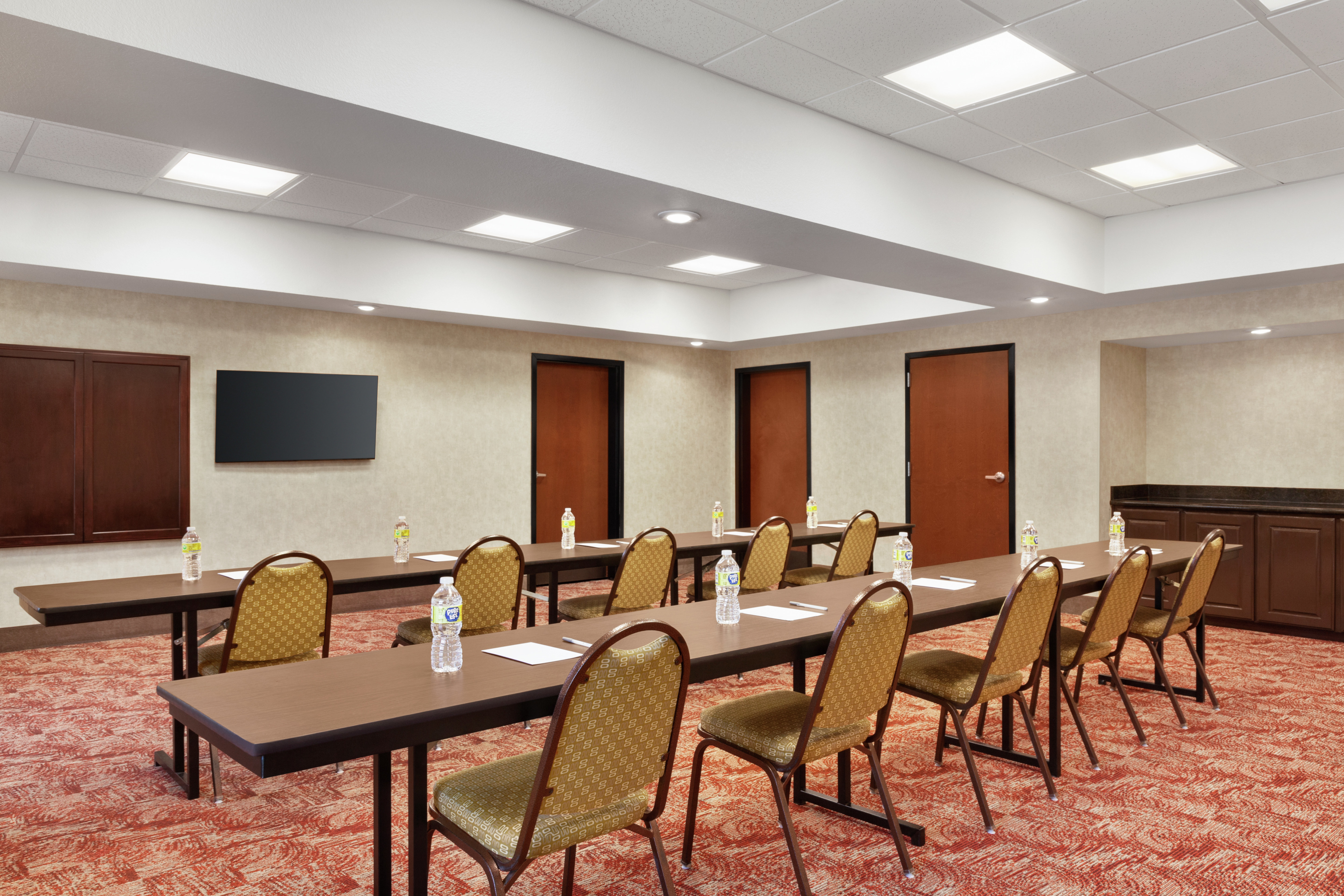 Spacious on-site meeting room featuring classroom style setup with TV at front of room.