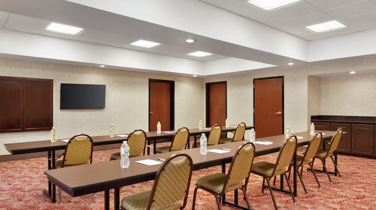 Spacious on-site meeting room featuring classroom style setup with TV at front of room.