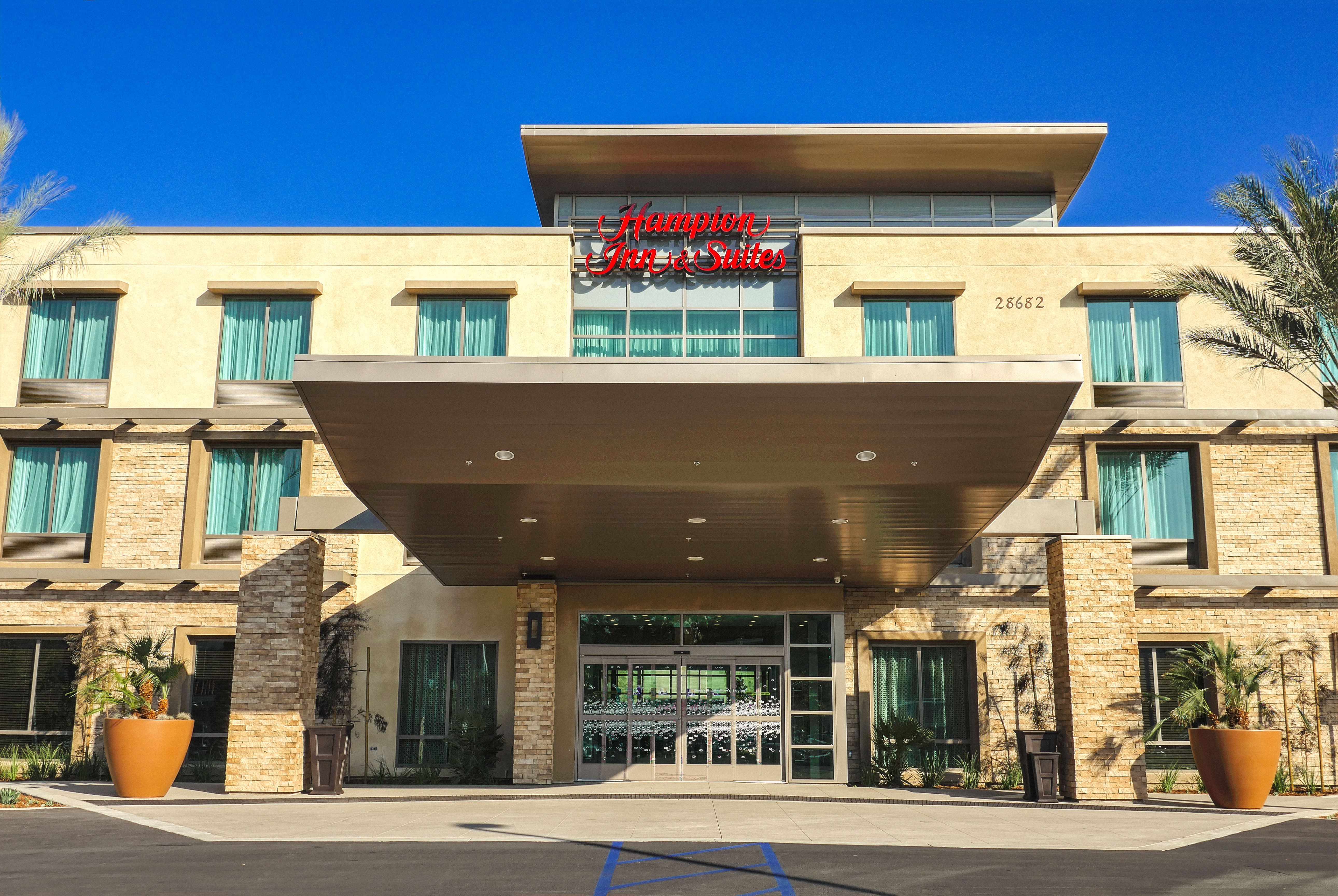 Daytime View of Hotel Exterior, Front Entrance and Signage