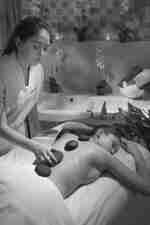 Woman Receiving Hot Stone Massage at Spa