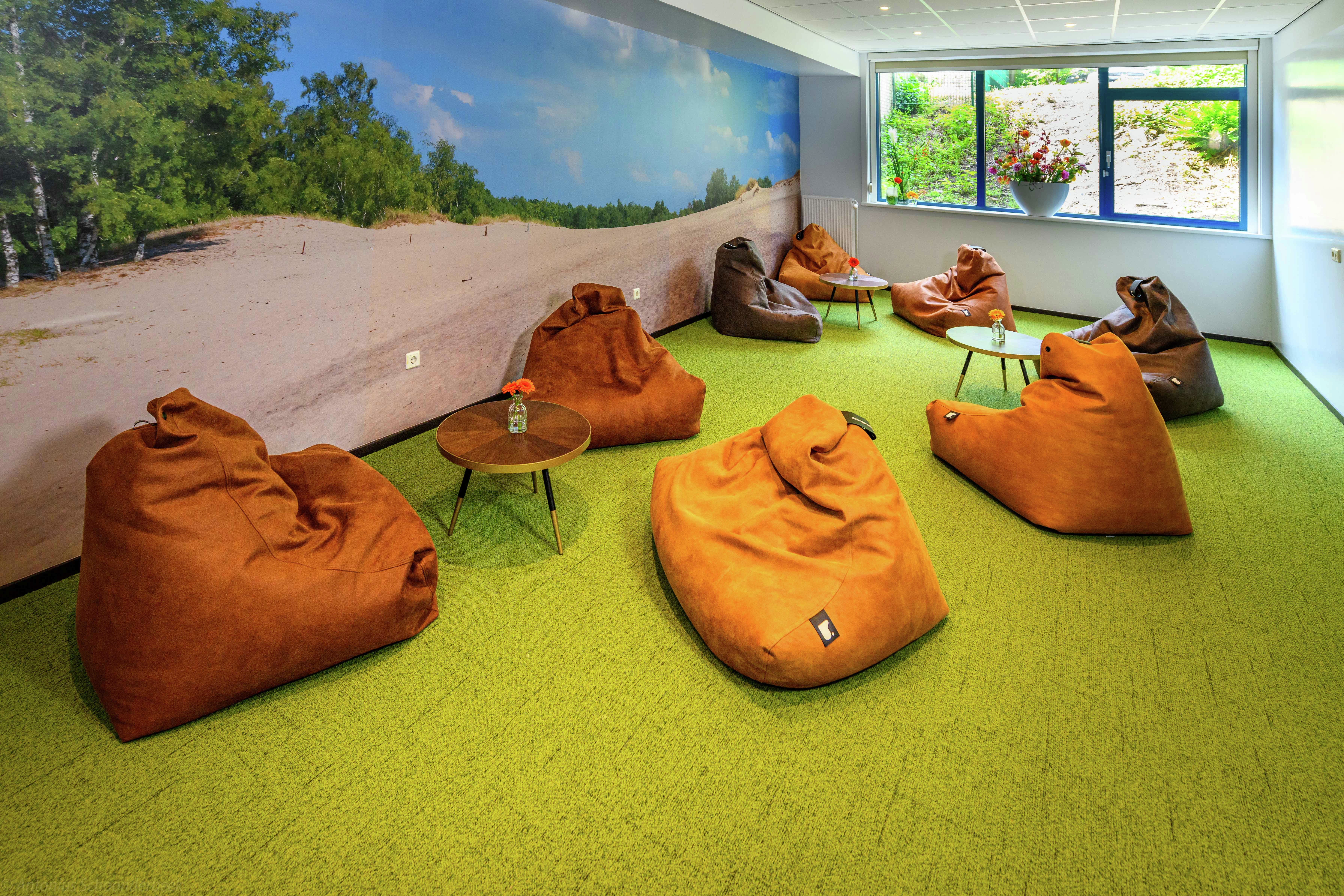 a casual seating area with large beanbag chairs and tables