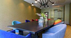 a meeting room with a long table and soft, colorful chairs