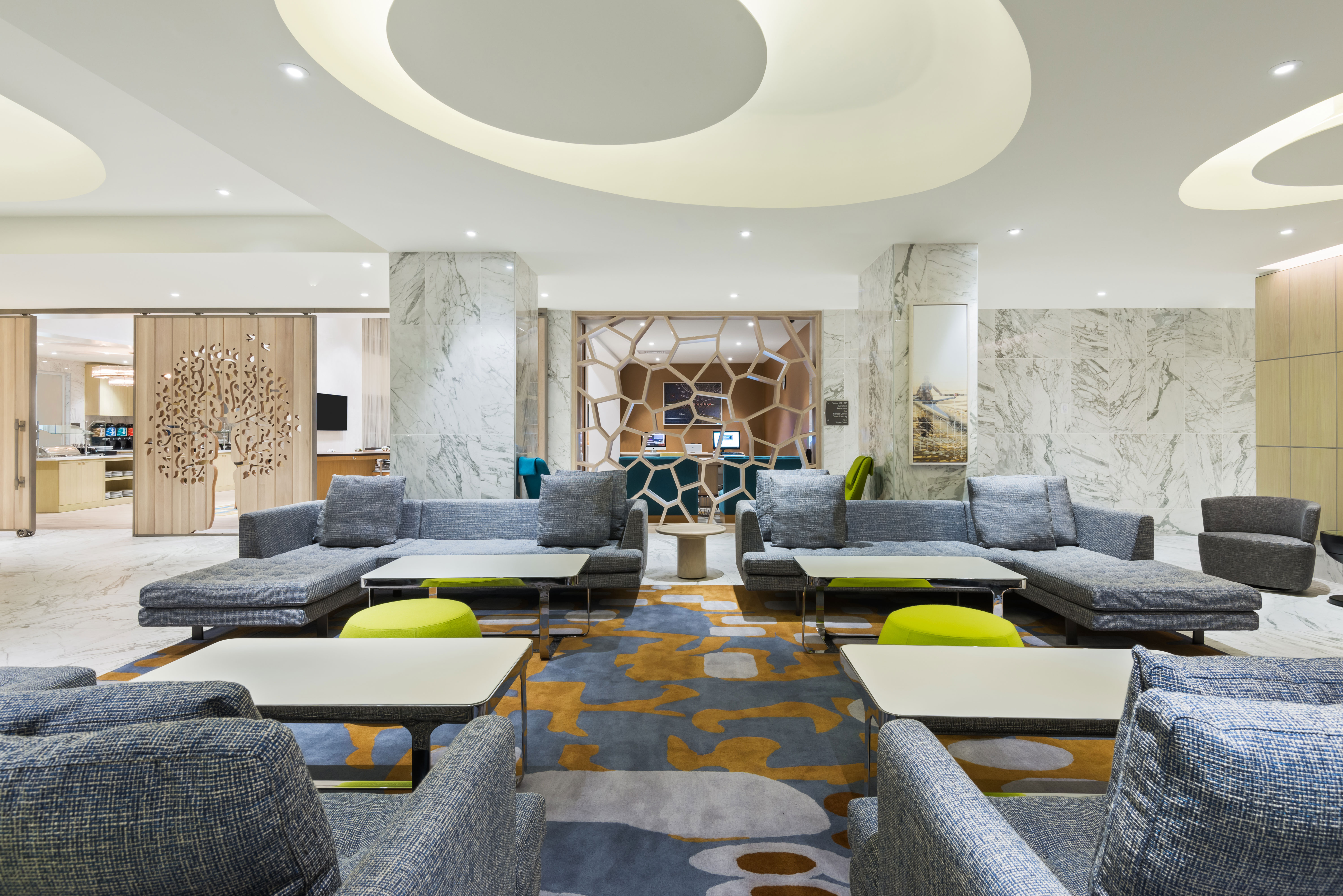 Four Large Grey Sofas with Square Tables and Two Yellow Ottomans in Lobby Seating Area