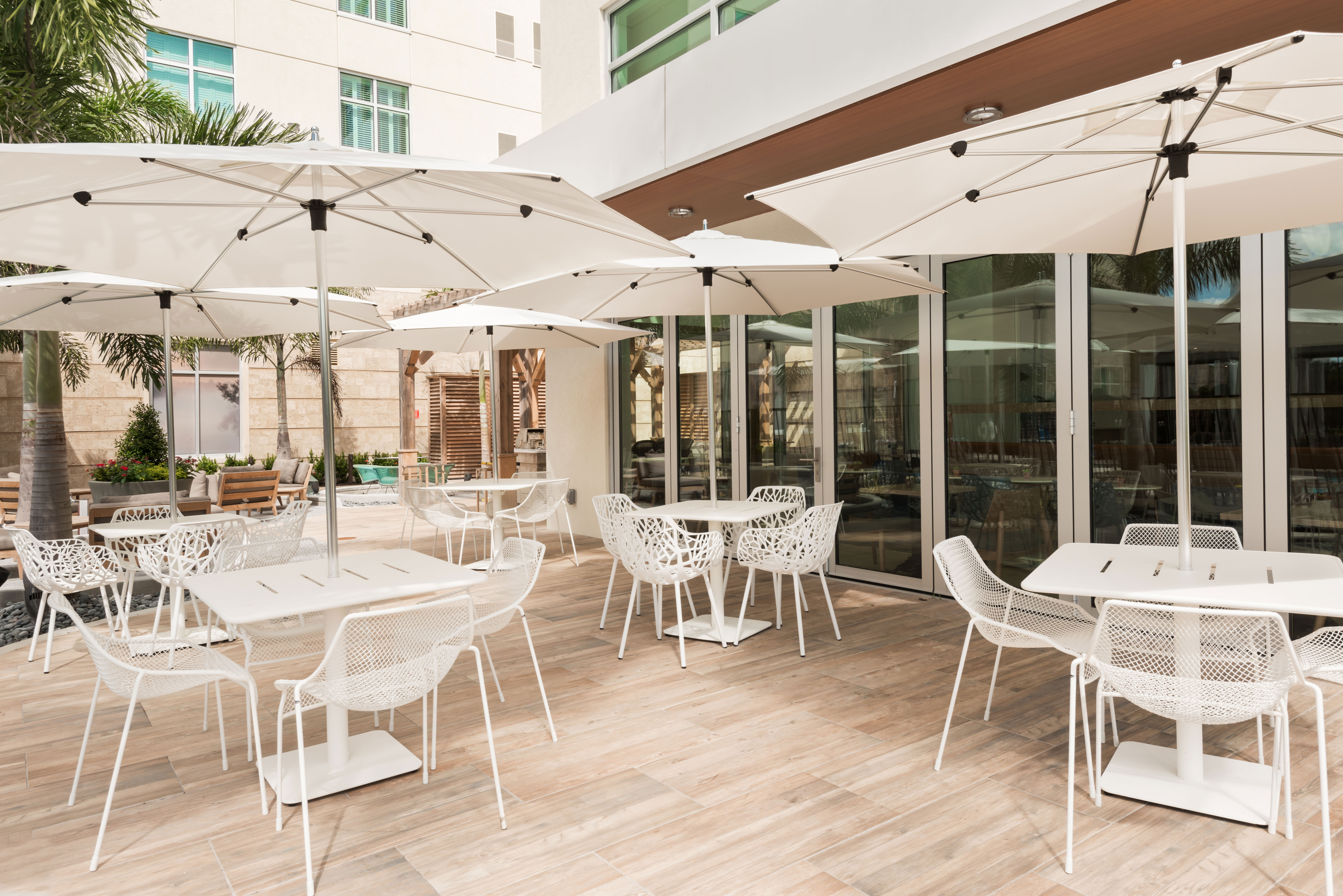 Outdoor Patio Seating With Five Tables, Chairs and Sun Umbrellas