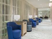 Blue and Grey Chairs in Hallway and Just Outside of Meeting Room With Draped Windows and Tall Square Tables