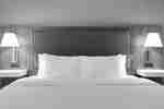 Close-up view of a king bed with bedside lamps