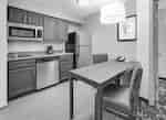Guest Suite Kitchen Area with Refridgerator, Dishwasher, Microwave, Two Chairs and Table