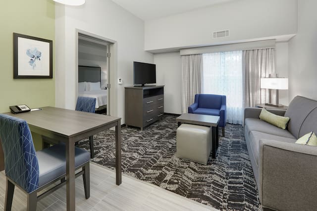 Guest Suite Livng Area with Sofa, Armchair, TV, Dining Table and Coffee Table