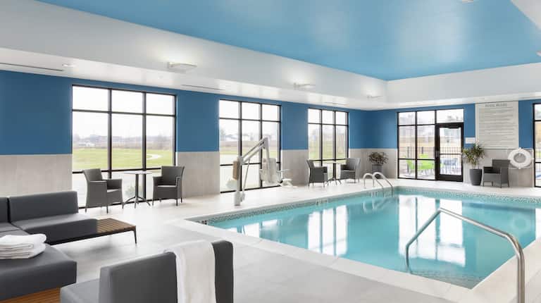an indoor pool and seating area