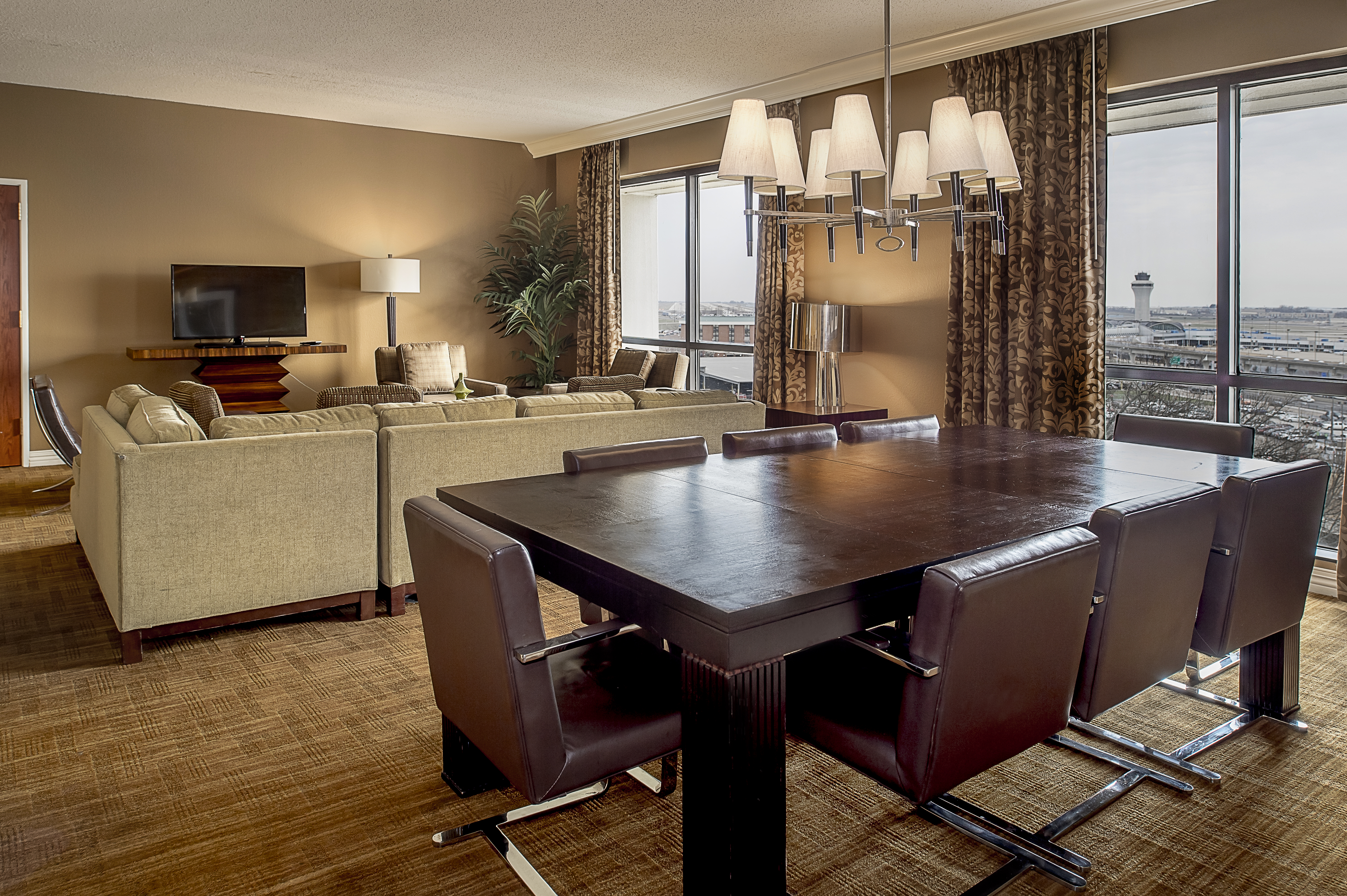 Presidential Suite Living Are with Dining Table, Couch, Television and Outside View