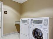 Entry Door, Folding Table, Washer, and Dryer in Laundry Room