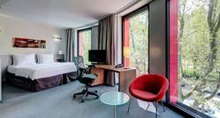 Bed, Desk and Chair by Floor-to-Ceiling Windows in Deluxe Room