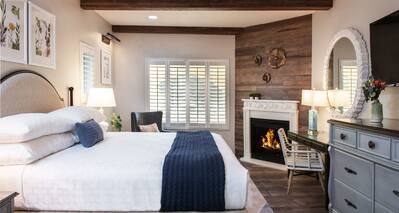 King bedroom with fireplace and wall mounted TV