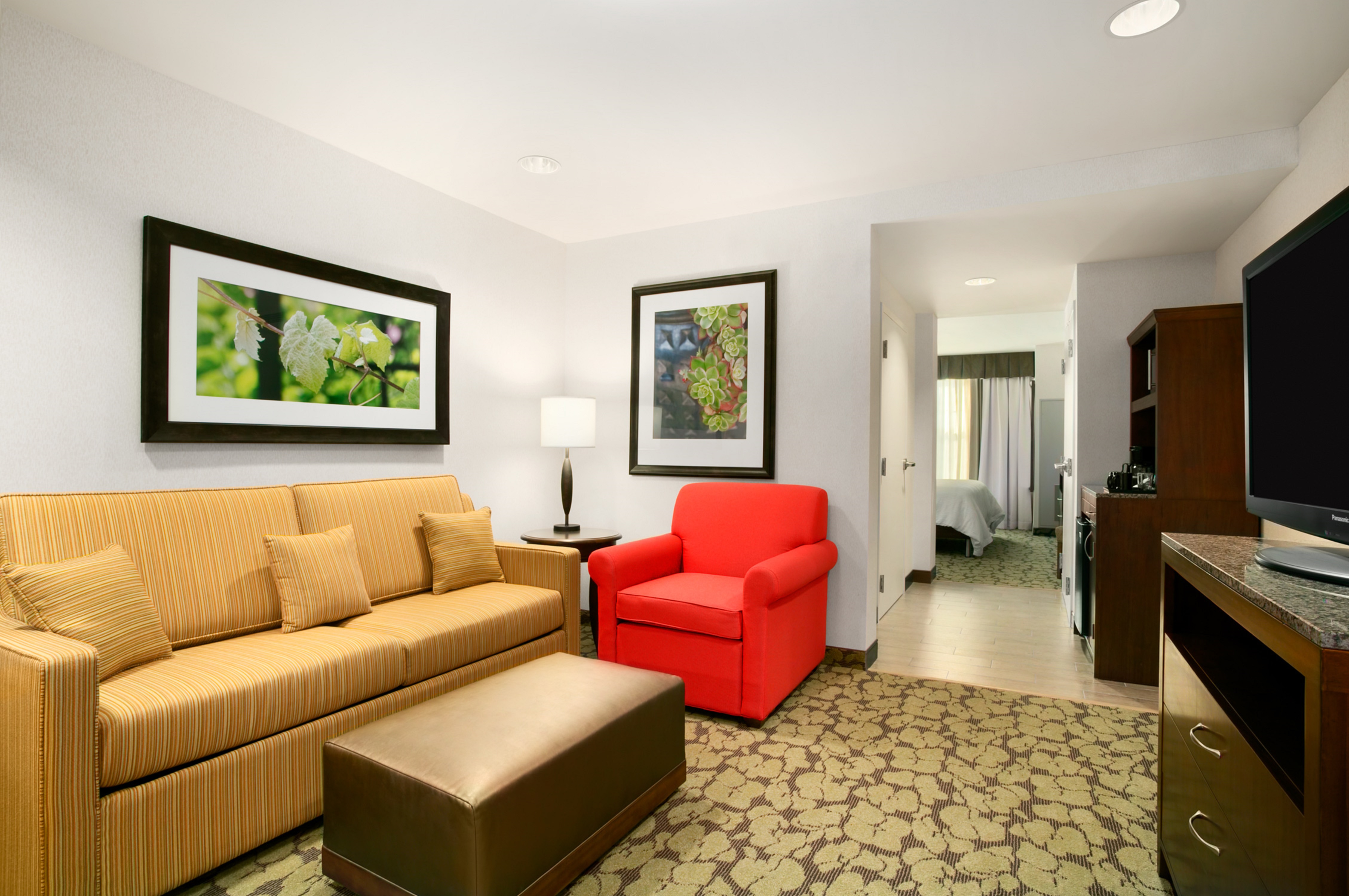 Guest Suite Lounge Area with Sofa, Armchair, Footrest, HDTV and Beverage Station