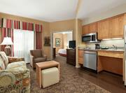 Spacious accessible suite with open concept living area, fully equipped kitchen, and private bedroom.
