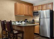 Spacious eat-in kitchen equipped with microwave, fridge, coffee maker, toaster, dishwasher, and cook-top stove. 