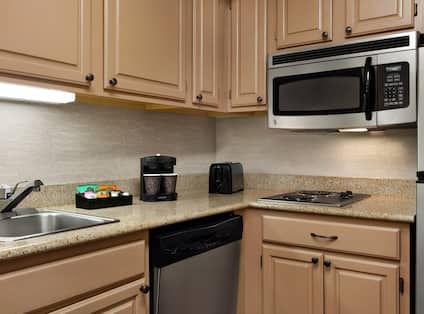 Spacious kitchen in suite featuring microwave, fridge, coffee maker, dishwasher, and cook-top stove. 