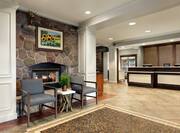 Welcoming lobby entrance with fireplace, front desk with HHonors program sign, snack shop and, rustic atmosphere.