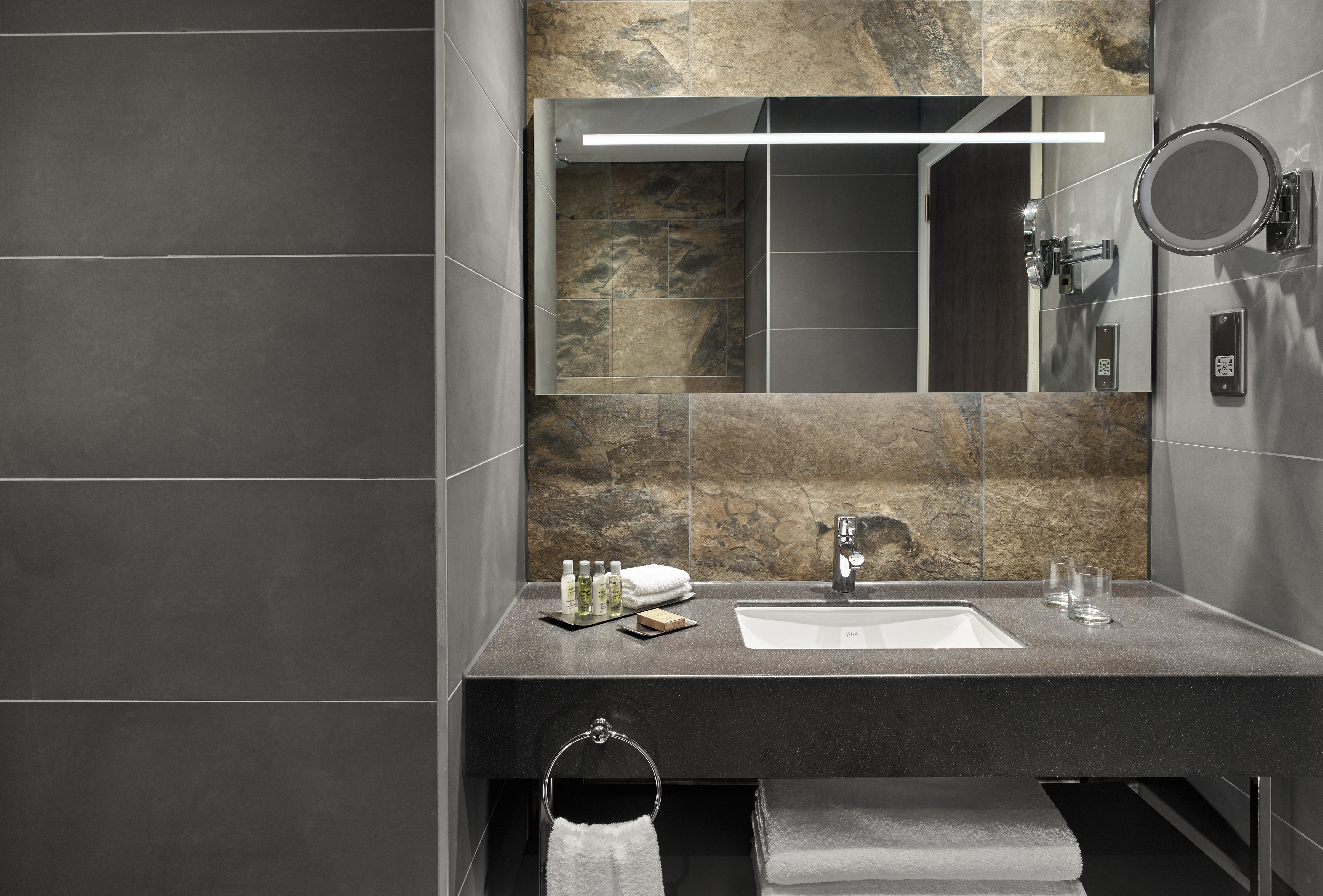 Deluxe en-suite bathroom  vanity mirror, sink, and towels