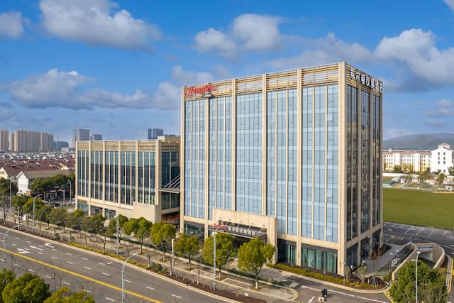 Hotel exterior with signage and trees