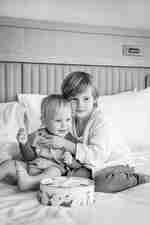 I bambini che tengono la teglia dei biscotti sul letto della camera