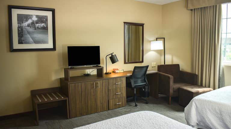 Guest Room with Two Beds Desk HDTV and Armchair