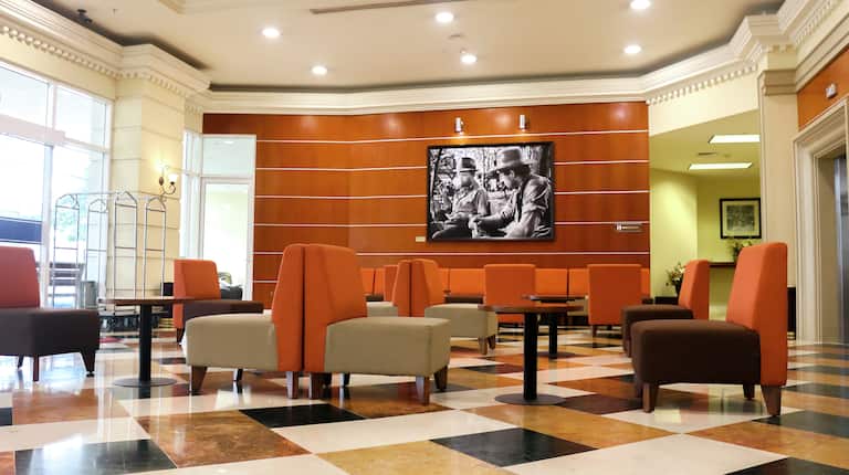 Lobby Seating Area with Soft Chairs, Tables and Wall Mounted HDTV