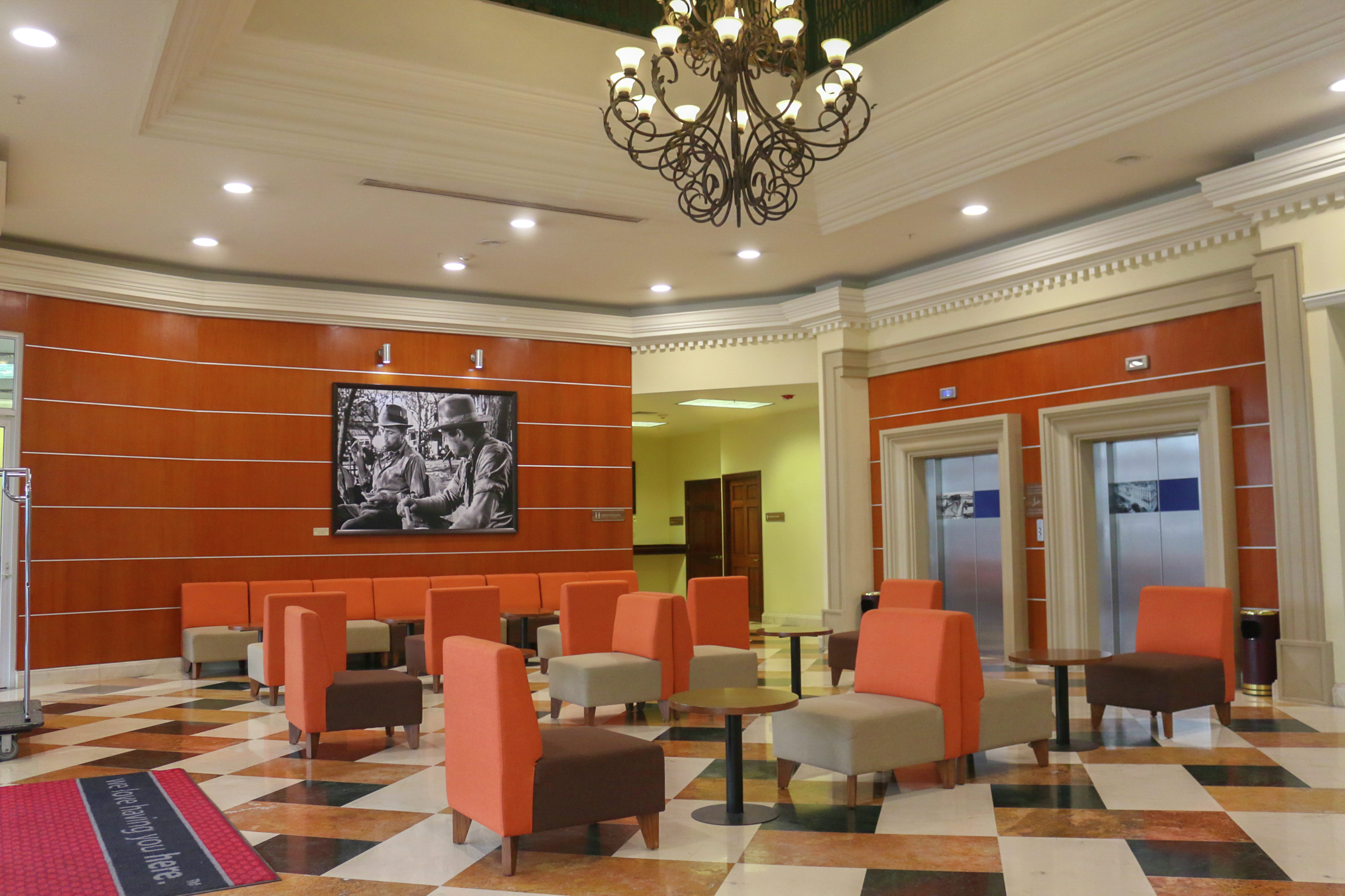 Lobby Seating Area with Soft Chairs, Tables and Wall Mounted HDTV