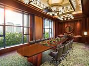 Board room with long table, chairs, and large windows with outdoor view