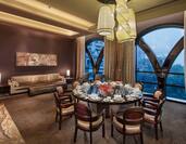 Chinese restaurant private room with dining table, chairs, dining amenities, lounge sofa, footrest, and windows with outdoor view