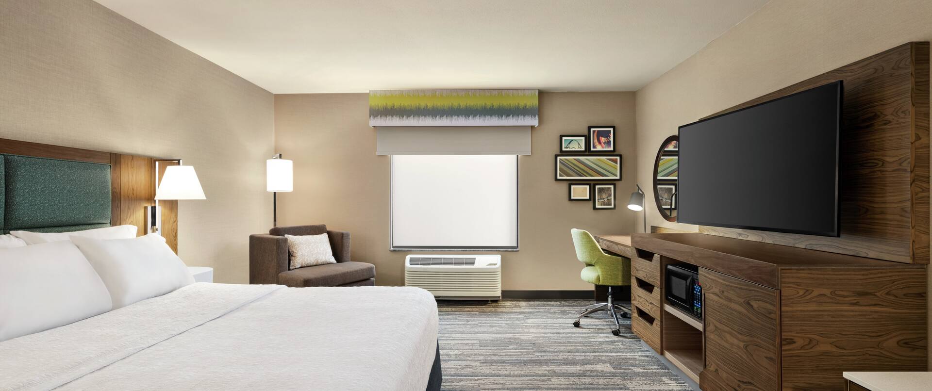Spacious accessible guest room featuring comfortable king bed, TV, and work desk.