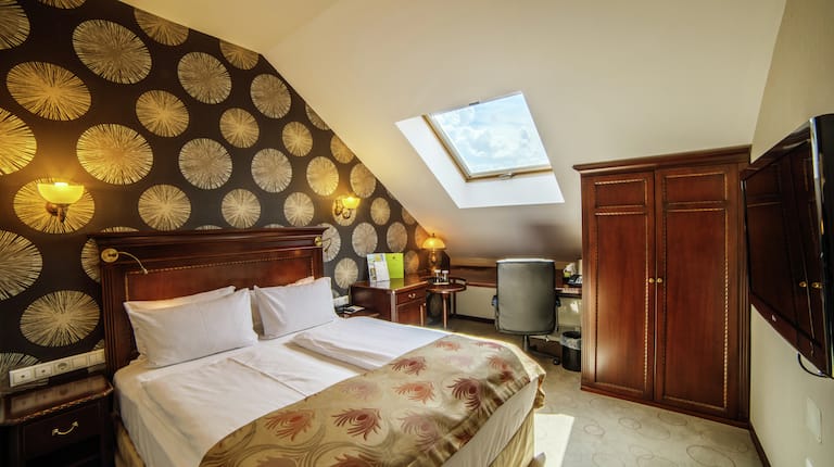 Beds in room with skylight and TV