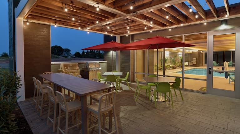 Outdoor patio featuring bbq grills, gazebo with string lights, and view of pool.