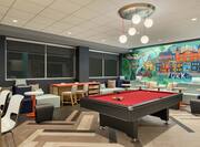 Open area with pool table and chair and table seating.