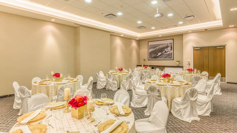Salón de fiestas con montaje para bodas, mesas redondas y sillas