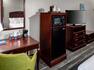 work desk, microwave, mini fridge, and tv in guestroom