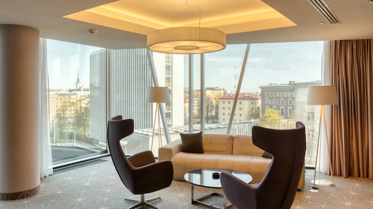 guest suite lounge area, sofa, coffee table, chairs, window view of the city